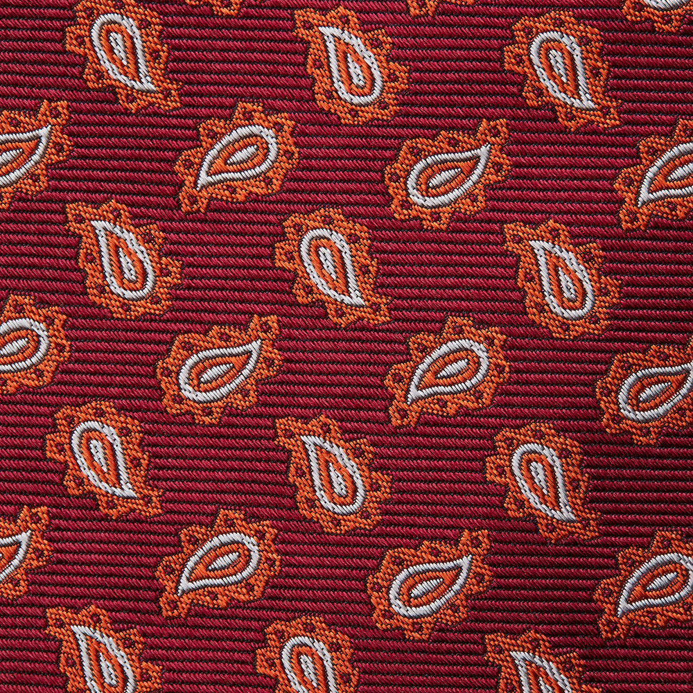 The Turnbull & Asser Red Abstract Paisley Silk Tie features bold orange and white paisley patterns on rich red silk—a stylish choice for fans of classic tailoring.