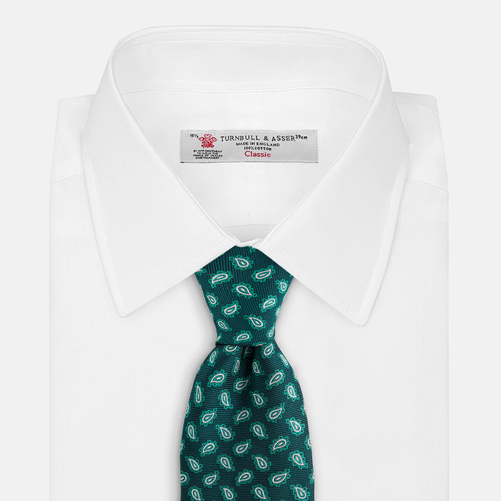 The Turnbull & Asser Green Abstract Paisley Silk Tie features a repeating light green paisley pattern on dark green silk, shown rolled up against a white background—a refined men’s accessory for making a statement.