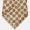 View 4 of product A cream floral geometric tie by Turnbull & Asser, rolled with the pointed end forward, is displayed on a white background.