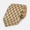 View 1 of product A cream floral geometric tie by Turnbull & Asser, rolled with the pointed end forward, is displayed on a white background.