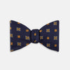 View 1 of product The Yellow Shields Bow Tie by Turnbull & Asser features a navy blue base with small yellow, orange, and white geometric squares, ideal for formal occasions and shown against a white background.