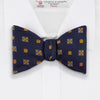 View 2 of product The Yellow Shields Bow Tie by Turnbull & Asser features a navy blue base with small yellow, orange, and white geometric squares, ideal for formal occasions and shown against a white background.