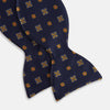 View 3 of product The Yellow Shields Bow Tie by Turnbull & Asser features a navy blue base with small yellow, orange, and white geometric squares, ideal for formal occasions and shown against a white background.