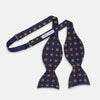 View 4 of product The Yellow Shields Bow Tie by Turnbull & Asser features a navy blue base with small yellow, orange, and white geometric squares, ideal for formal occasions and shown against a white background.