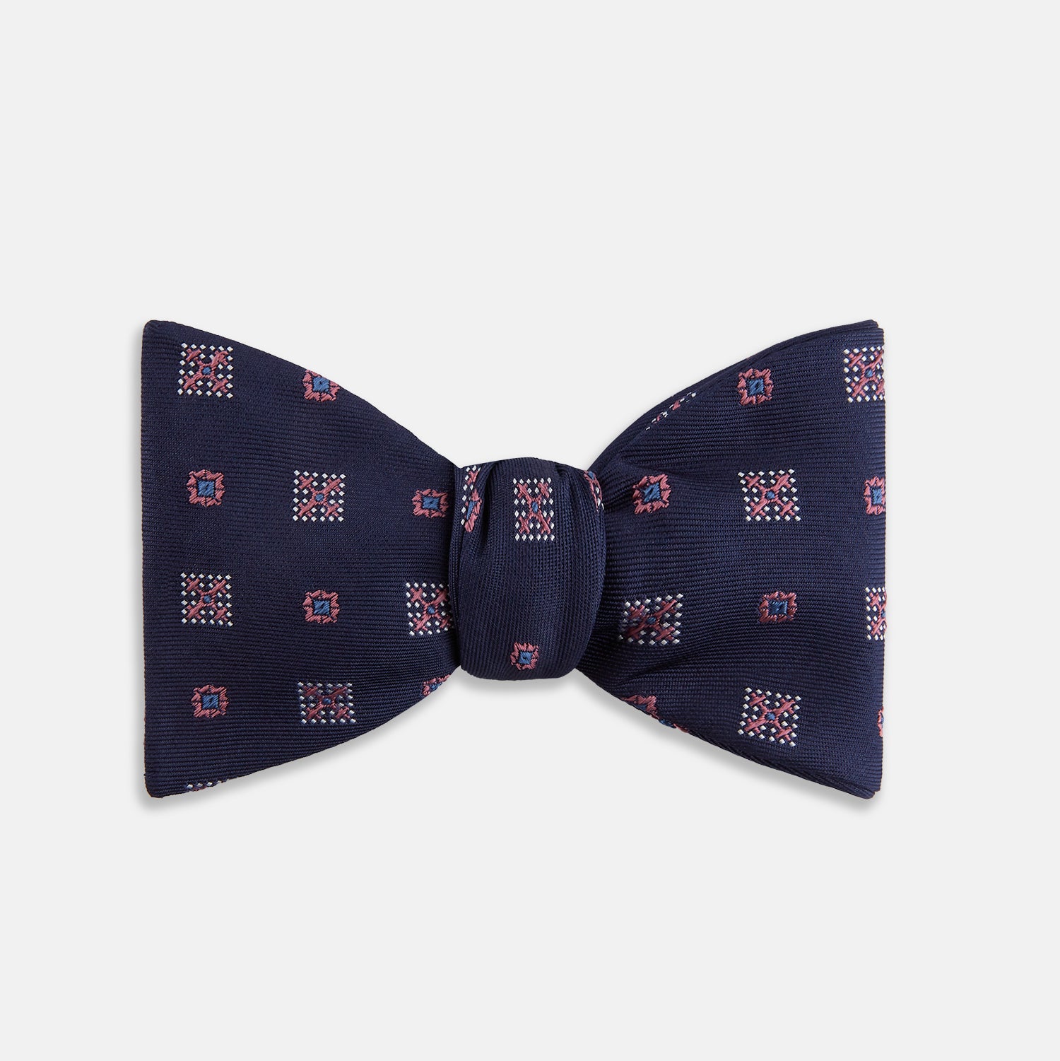 View 1 of product The Turnbull & Asser Pink Shields Bow Tie features a pink pattern with shield motifs, ideal for formal occasions and displayed on a plain white background.