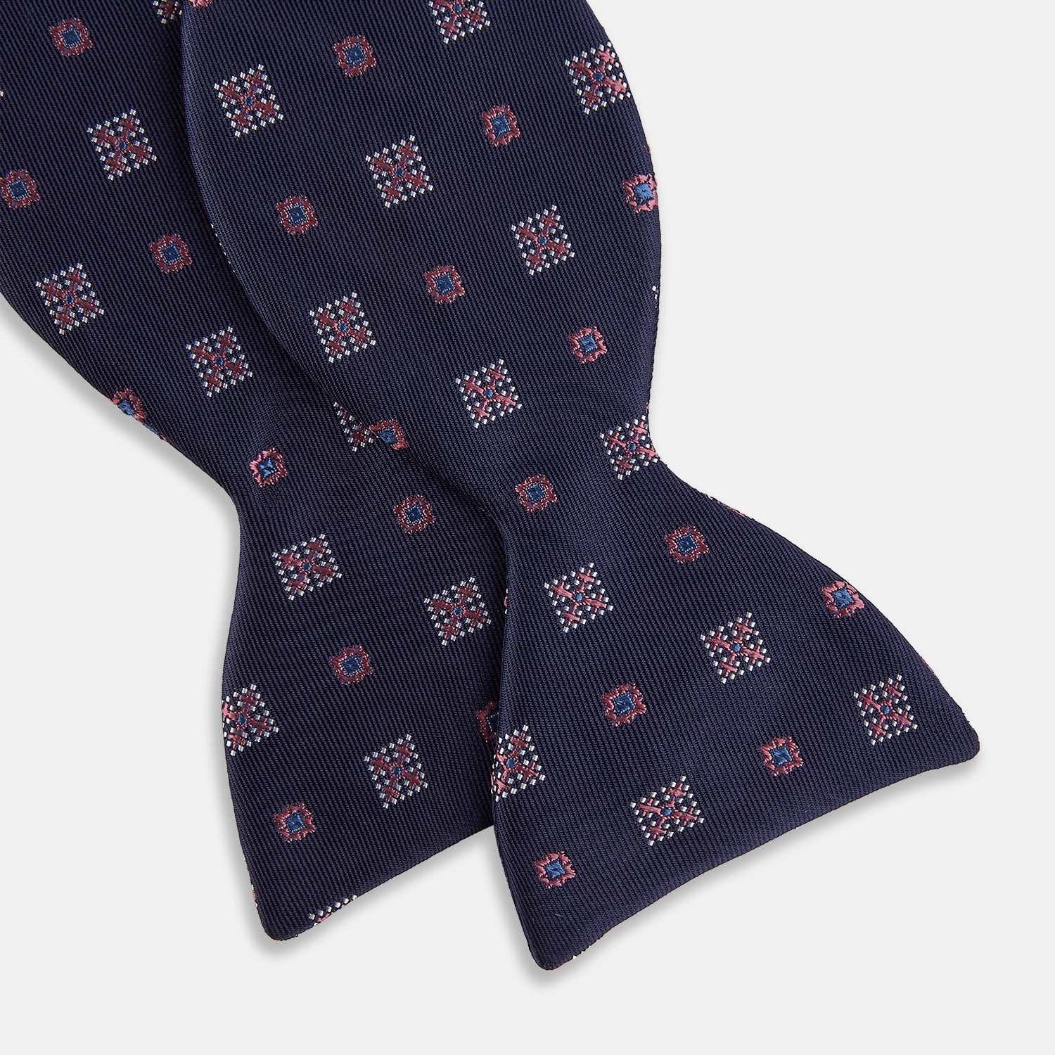 View 3 of product The Turnbull & Asser Pink Shields Bow Tie features a pink pattern with shield motifs, ideal for formal occasions and displayed on a plain white background.