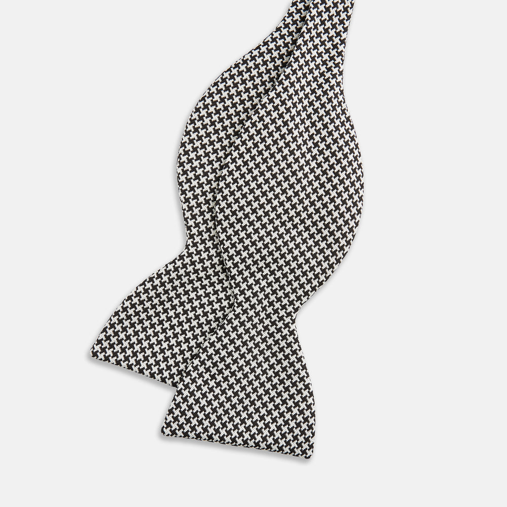 The Turnbull & Asser Fine Puppytooth Monochrome Silk Bow Tie, shown on a white background, features a black and white puppytooth pattern—ideal for wearing with formalwear or an evening shirt.