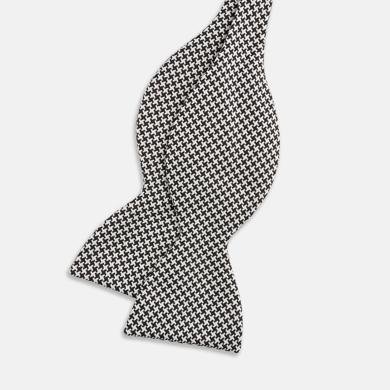 View 2 of product The Turnbull & Asser Fine Puppytooth Monochrome Silk Bow Tie, shown on a white background, features a black and white puppytooth pattern—ideal for wearing with formalwear or an evening shirt.