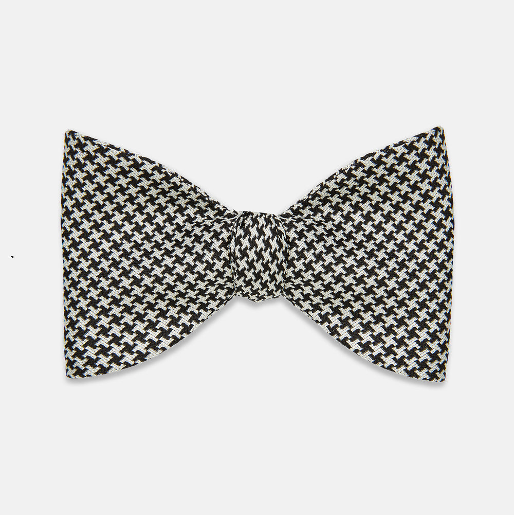 The Turnbull & Asser Fine Puppytooth Monochrome Silk Bow Tie, shown on a white background, features a black and white puppytooth pattern—ideal for wearing with formalwear or an evening shirt.