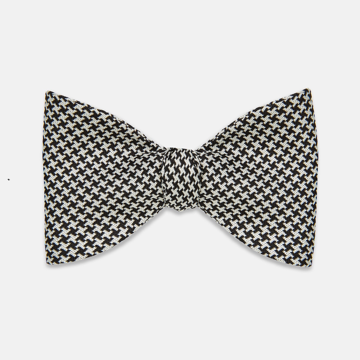 View 1 of product The Turnbull & Asser Fine Puppytooth Monochrome Silk Bow Tie, shown on a white background, features a black and white puppytooth pattern—ideal for wearing with formalwear or an evening shirt.