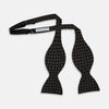 View 3 of product The Floral Piqué Monochrome Silk Bow Tie by Turnbull & Asser, featuring a repeating pattern of small white dots and hexagons on black silk, is ideal for formalwear or a dinner suit and is shown against a plain white background.