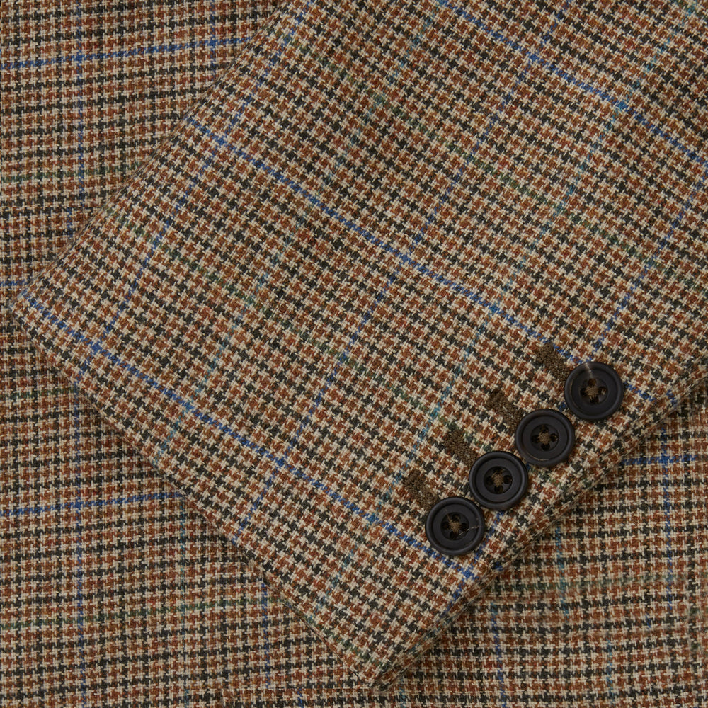 The Byron Wool Check Travel Jacket by Turnbull & Asser features a brown plaid pattern, notched lapel, four flap utility pockets, and dark buttons. This lightweight wool jacket is shown on a plain white background.
