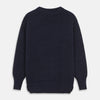 View 2 of product A man stands in the Turnbull & Asser Navy Lewis Guernsey Knitted Jumper.