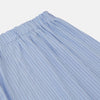 View 3 of product A man stands barefoot against a plain background, wearing a white short-sleeve T-shirt and Turnbull & Asser Blue Stripe Cotton Pyjama Trousers in a contemporary fit, looking straight ahead with a neutral expression.