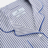 View 2 of product The Women's Dara Navy Stripe Pyjama Set by Turnbull & Asser features a long-sleeve button-up shirt with chest pocket and drawstring pants in premium cotton, shown neatly on a white background.