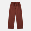 View 6 of product The Turnbull & Asser Red Cotton-Cashmere Pyjama Set features a rust-red long-sleeve button-up top with chest pocket and matching waist-tied pants, shown on a plain white background.