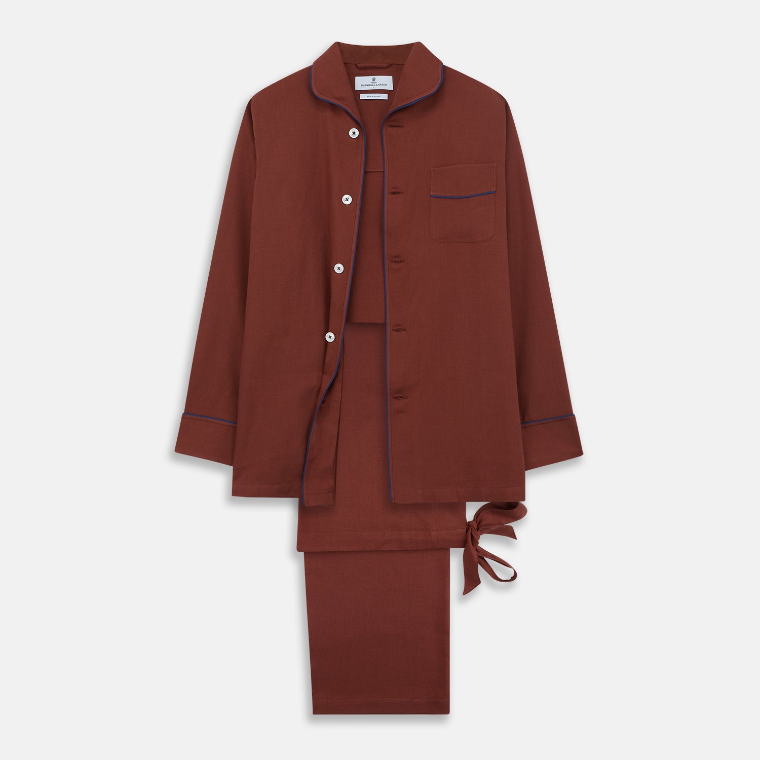 View 1 of product The Turnbull & Asser Red Cotton-Cashmere Pyjama Set features a rust-red long-sleeve button-up top with chest pocket and matching waist-tied pants, shown on a plain white background.