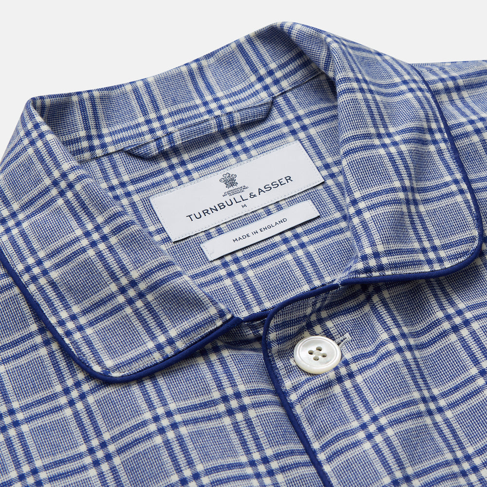 The Turnbull & Asser Blue Check Modern Cotton Pyjama Set features a long-sleeve button-up top and matching pants, crafted from thicker cotton for added comfort, shown against a white background.