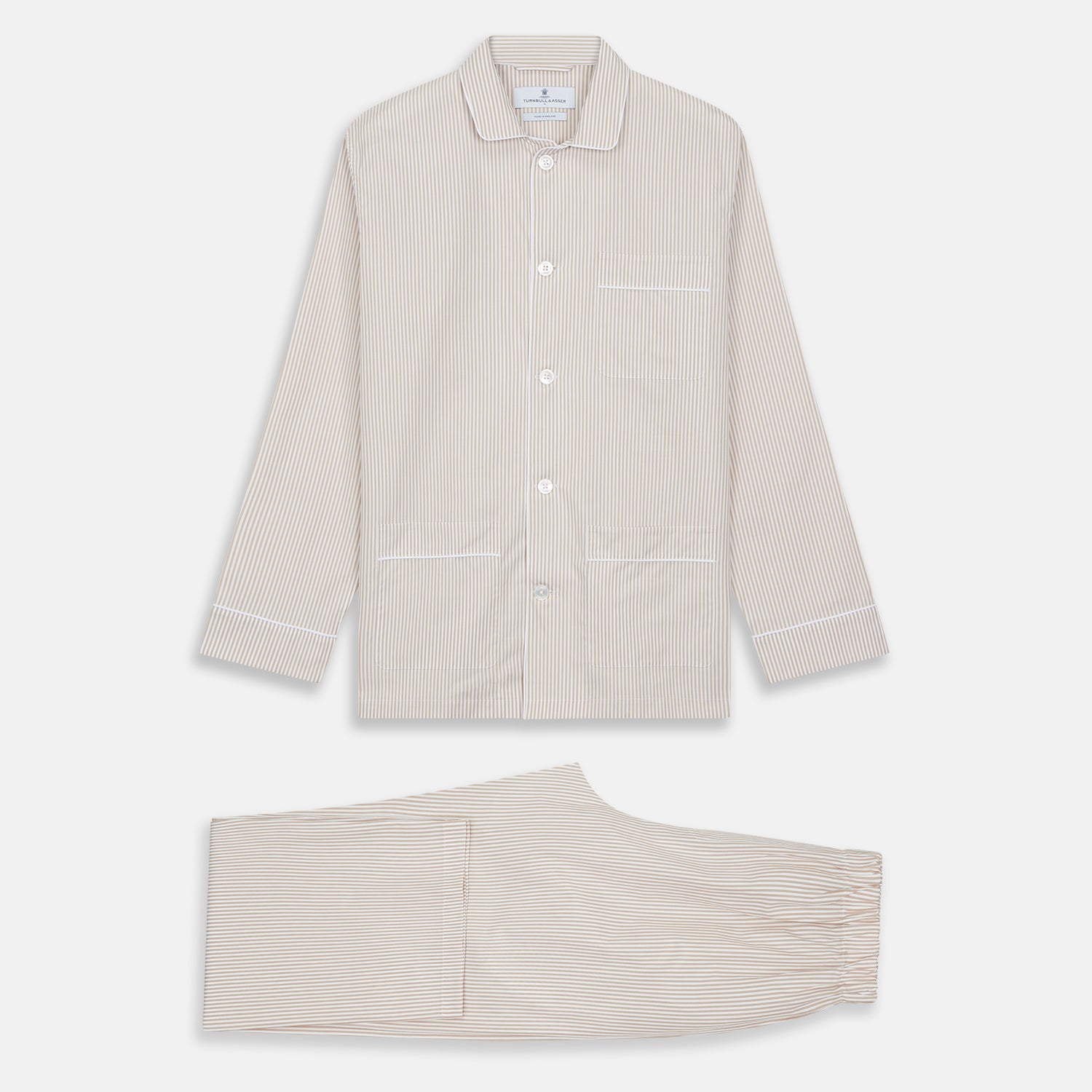 View 6 of product The Turnbull & Asser Sand Bengal Stripe Modern Fit Cotton Pyjama Set features cream-colored striped Italian cotton, with a long-sleeved button-up top and matching drawstring pants, neatly displayed against a white background.
