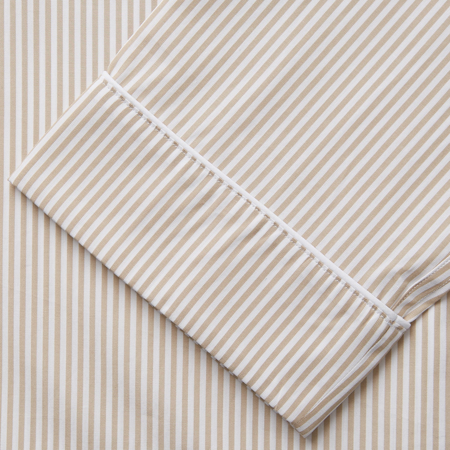View 3 of product The Turnbull & Asser Sand Bengal Stripe Modern Fit Cotton Pyjama Set features cream-colored striped Italian cotton, with a long-sleeved button-up top and matching drawstring pants, neatly displayed against a white background.