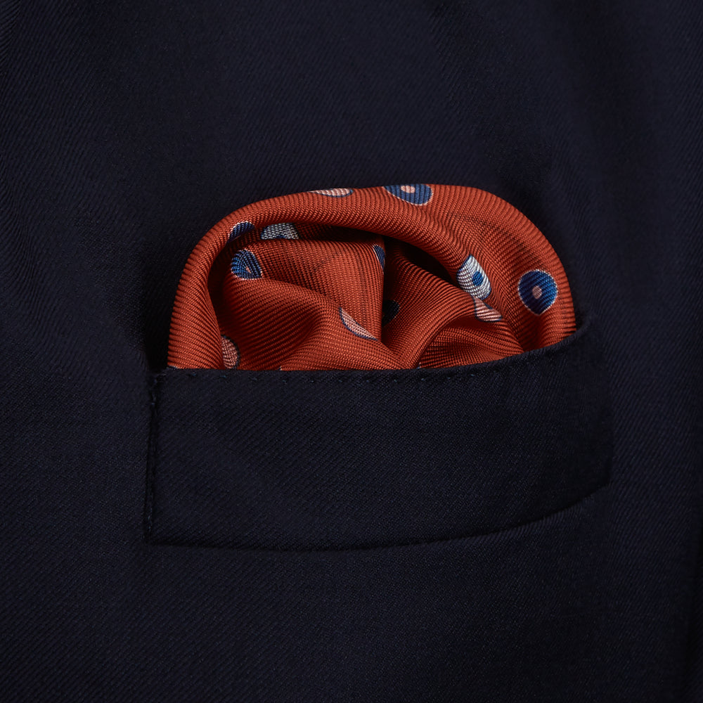 The Turnbull & Asser Red Windsurfer Double-Faced Silk Print Pocket Square features a vibrant windsurfer pattern on silk with a dark blue border and the brand subtly printed in one corner.