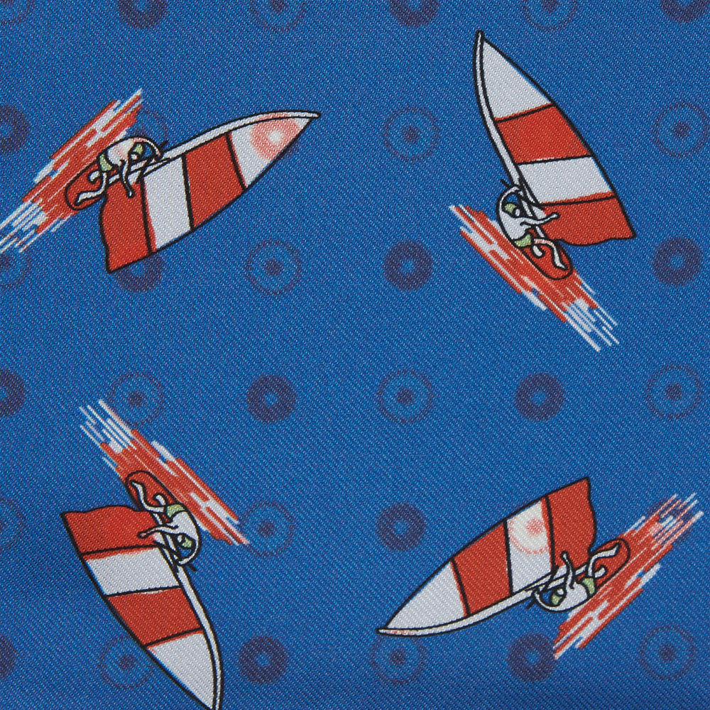 The Turnbull & Asser Blue Windsurfer Double-Faced Silk Print Pocket Square features a blue silk design with colorful windsurfers and vivid red edges, finished with the Turnbull & Asser logo in one corner.