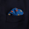 View 6 of product The Turnbull & Asser Blue Windsurfer Double-Faced Silk Print Pocket Square features a blue silk design with colorful windsurfers and vivid red edges, finished with the Turnbull & Asser logo in one corner.