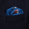 View 4 of product The Turnbull & Asser Blue Windsurfer Double-Faced Silk Print Pocket Square features a blue silk design with colorful windsurfers and vivid red edges, finished with the Turnbull & Asser logo in one corner.