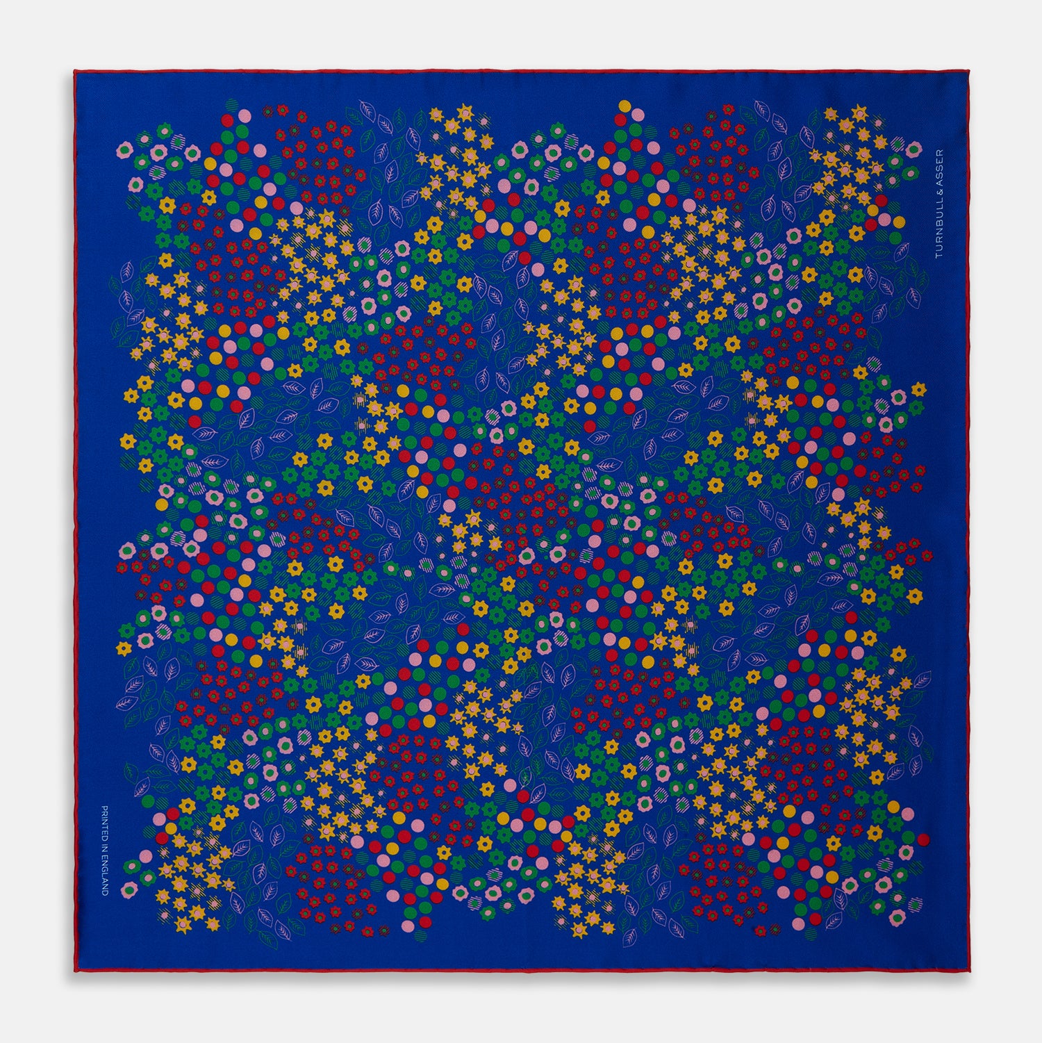 View 1 of product The Turnbull & Asser Navy Abstract Floral Silk Pocket Square features a vibrant blue base with colorful flowers, dots, and leaves arranged in a symmetrical geometric design for a sharp, tailored look.