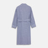 View 5 of product The Turnbull & Asser Navy Check Cotton Gown features long sleeves, white piping, a shawl collar, chest pocket, and matching waist belt, all in a blue plaid pattern. Shown against a plain white background.