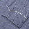 View 3 of product The Turnbull & Asser Navy Check Cotton Gown features long sleeves, white piping, a shawl collar, chest pocket, and matching waist belt, all in a blue plaid pattern. Shown against a plain white background.
