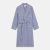 View 1 of product The Turnbull & Asser Navy Check Cotton Gown features long sleeves, white piping, a shawl collar, chest pocket, and matching waist belt, all in a blue plaid pattern. Shown against a plain white background.