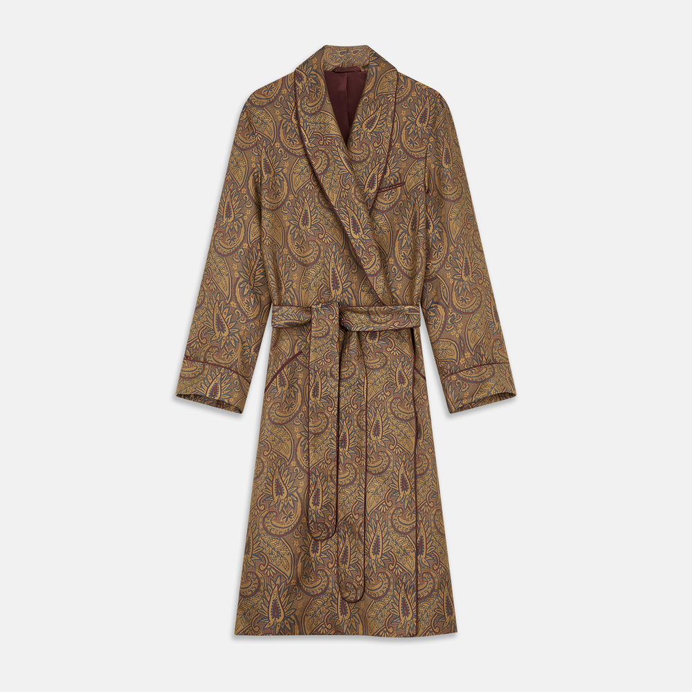 The Turnbull & Asser Gold Paisley Traditional Silk Jacquard Gown features a brown and gold paisley pattern, shawl collar, front pockets, and matching fabric belt. Displayed on a white background, it’s perfect for winter comfort.