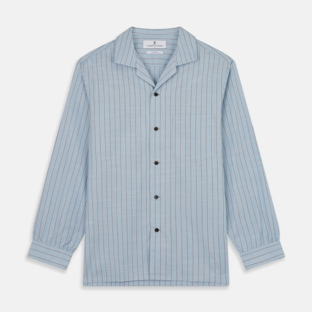 Turnbull & Asser's Pale Blue Stripe Cotton Holiday Fit Shirt features a revere collar, thin black pinstripes, single button cuff, chest pocket, and black buttons—crafted from Italian cotton and laid flat on a white background.