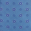 View 3 of product The Blue Multi Floral Motif Silk Tie by Turnbull & Asser features subtle diagonal stripes and blue and white floral medallions on light blue silk—ideal for bold shirts. The tie is shown rolled at one end.