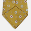 View 4 of product The Yellow Multi Floral Motif Silk Tie by Turnbull & Asser features subtle diagonal stripes and small white, blue, and orange floral motifs—a perfect summer palette, shown rolled up on a plain white background.