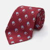 View 1 of product The Turnbull & Asser Red Multi Circle Silk Tie features small blue and white rings on red silk, making it ideal for pairing with bold shirts or adding vibrant flair to summer looks. Shown rolled at one end against a plain white background.