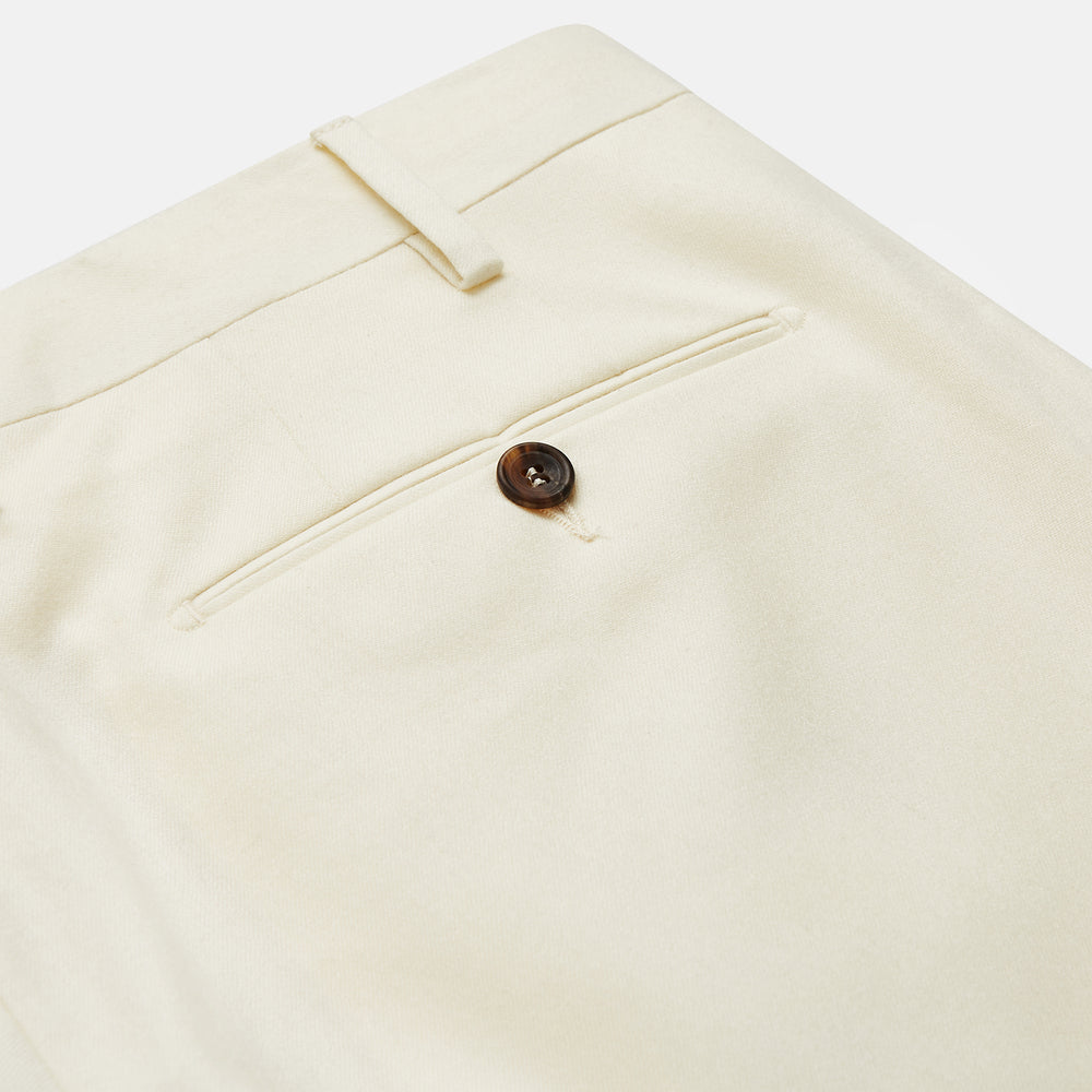 The Cream Lightweight Wool Pleated Jasper Trouser by Turnbull & Asser features side pockets and a button closure, expertly crafted from lightweight wool in cream and displayed on a plain white background.