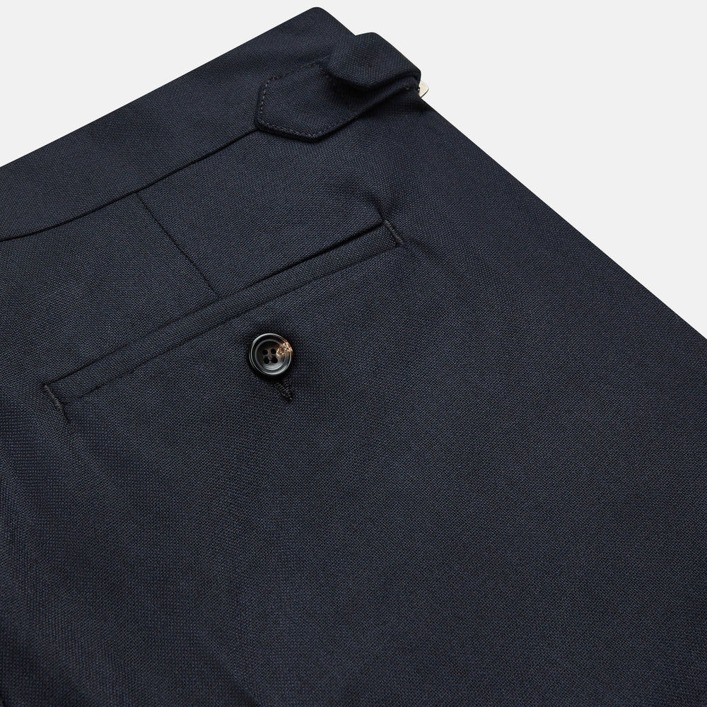 The Navy Escorial Wool Jonathan Trousers by Turnbull & Asser, featuring side adjusters, front pleats, and side pockets, are shown laid flat on a white background.