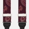 View 2 of product Two red paisley adjustable silk braces by Turnbull & Asser, featuring leather ends and silver clasps, are laid out vertically side by side on a white background.
