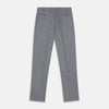 View 7 of product A person wears Turnbull & Asser Grey Puppytooth Wool Manson Trousers, a white dress shirt with rolled-up sleeves, and black shoes, standing against a plain beige background.