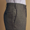 View 5 of product A person wears Turnbull & Asser Grey Puppytooth Wool Manson Trousers, a white dress shirt with rolled-up sleeves, and black shoes, standing against a plain beige background.