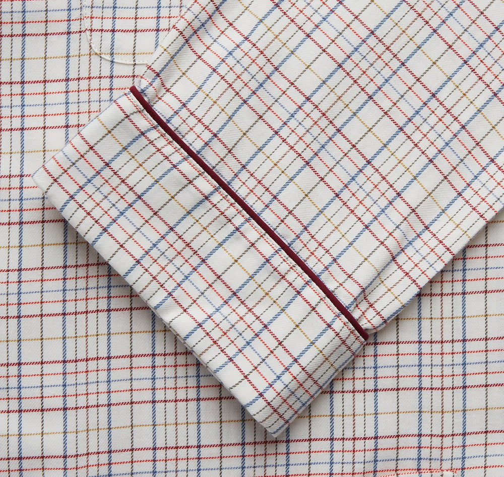 The Turnbull & Asser Red Multi Check Cotton-Cashmere Modern Pyjama Set, made in England, features a long-sleeve button-up shirt and pants in red and gray plaid with dark piping, crafted from soft Italian cotton-cashmere.