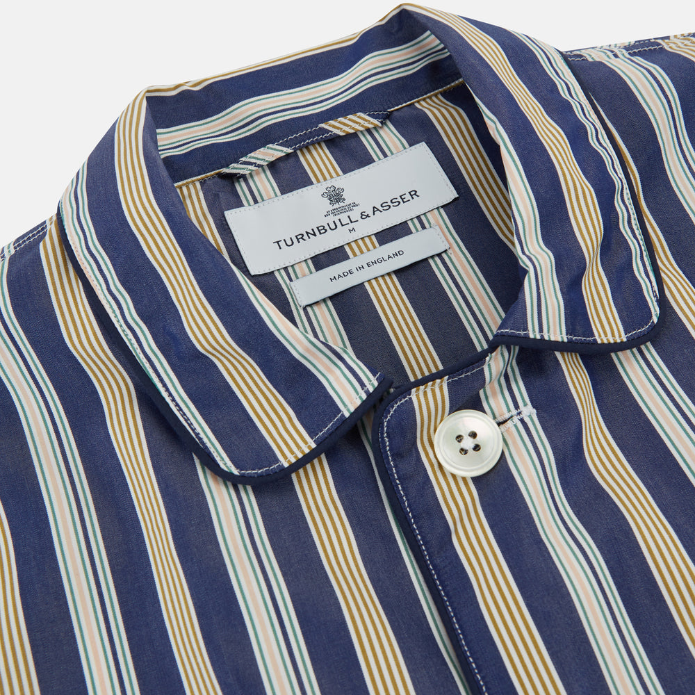 Turnbull & Asser's Blue Multi Stripe Cotton Modern Pyjama Set features a camp collar shirt with white buttons, front pocket, and long sleeves. Both pieces showcase classic blue and beige stripes for a timeless look.