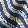 View 4 of product Turnbull & Asser's Blue Multi Stripe Cotton Modern Pyjama Set features a camp collar shirt with white buttons, front pocket, and long sleeves. Both pieces showcase classic blue and beige stripes for a timeless look.