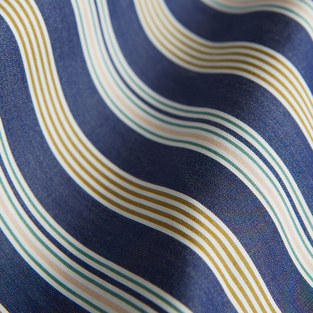 Turnbull & Asser's Blue Multi Stripe Cotton Modern Pyjama Set features a camp collar shirt with white buttons, front pocket, and long sleeves. Both pieces showcase classic blue and beige stripes for a timeless look.