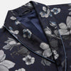 View 3 of product The Navy Floral Silk Jacquard Pierce Gown by Turnbull & Asser features a shawl collar, long sleeves, matching fabric belt, and elegant grey and blue floral design.