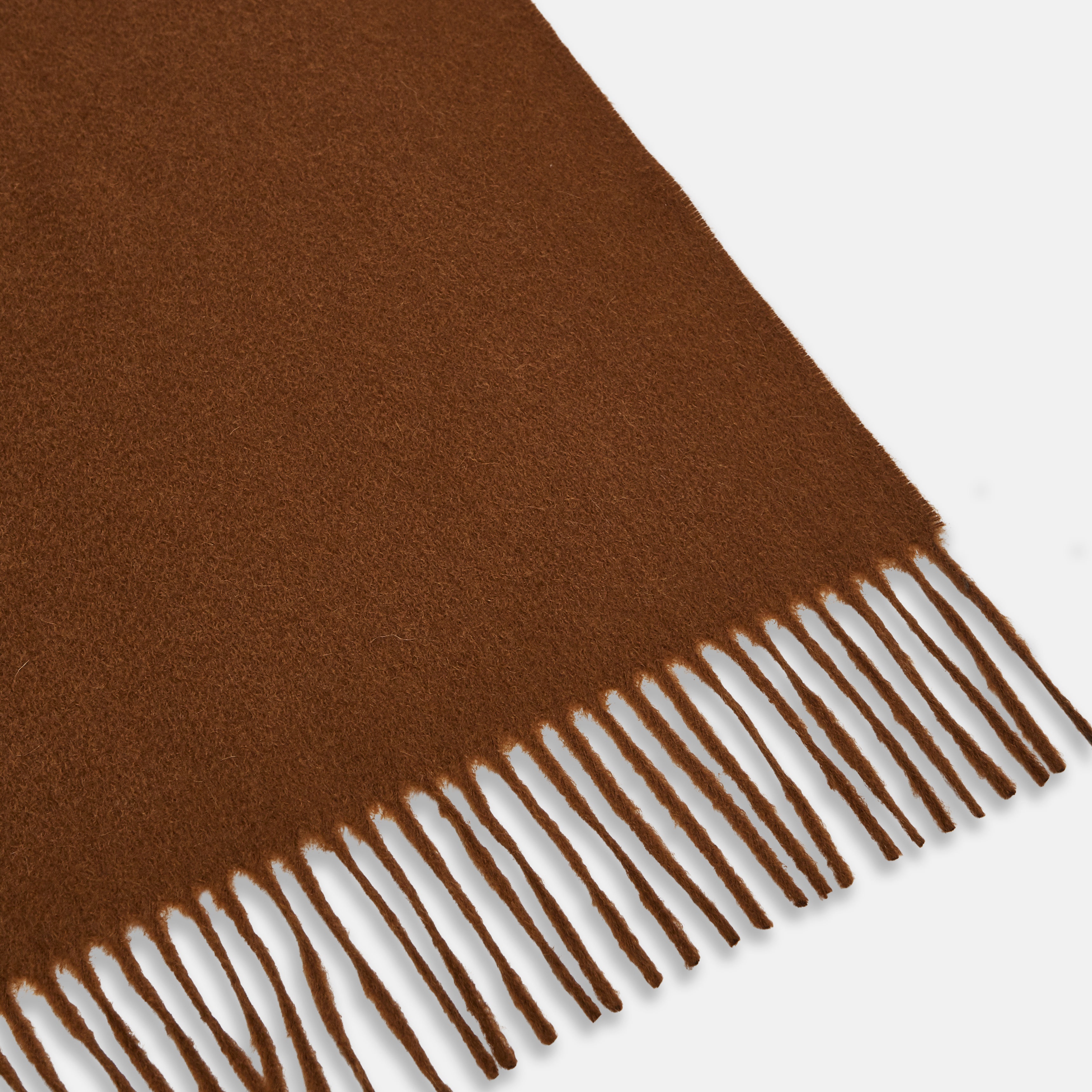 View 2 of product The Turnbull & Asser Rust Cashmere Wilde Stole Scarf is oversized with a soft texture, features short fringe detailing on the ends, and is shown loosely tied against a plain white background.