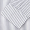 View 4 of product A man wearing the Turnbull & Asser Grey Multi Stripe Regular Fit Twill Shirt with T&A Collar and Double Cuffs stands against a beige background, one hand in his pocket, looking at the camera.