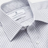 View 3 of product A man wearing the Turnbull & Asser Grey Multi Stripe Regular Fit Twill Shirt with T&A Collar and Double Cuffs stands against a beige background, one hand in his pocket, looking at the camera.
